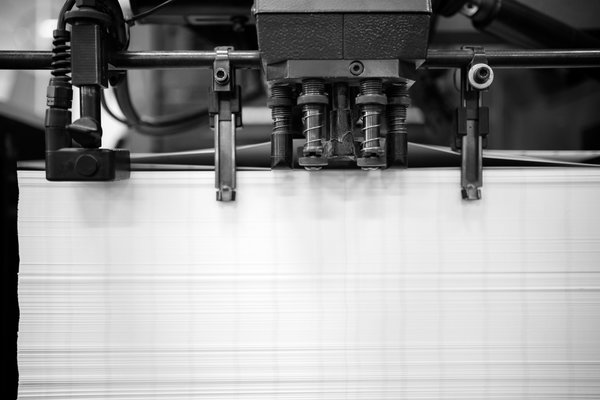 Die Herstellung von Postkarten in der Offsetdruckerei: Papierzufuhr der Offsetdruckmaschine.